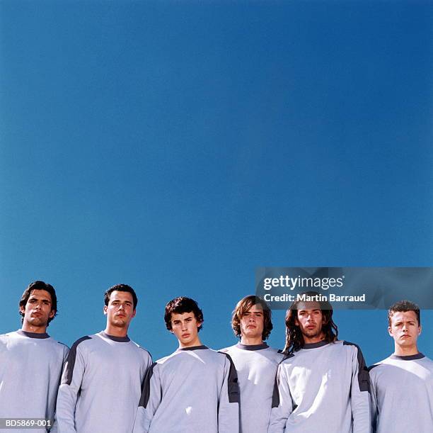 group of young men wearing identical clothing, portrait - cloning stock-fotos und bilder