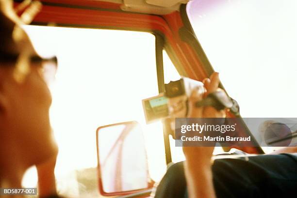 woman looking through video camera in car - lech stock pictures, royalty-free photos & images