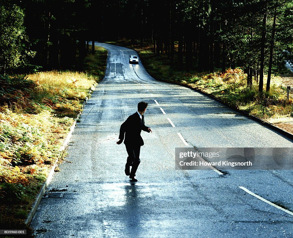 Businessman being chased by car