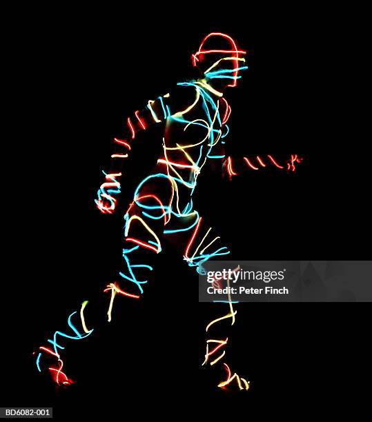 young woman in running stance, neon light wires wrapped around body - man and machine stock pictures, royalty-free photos & images