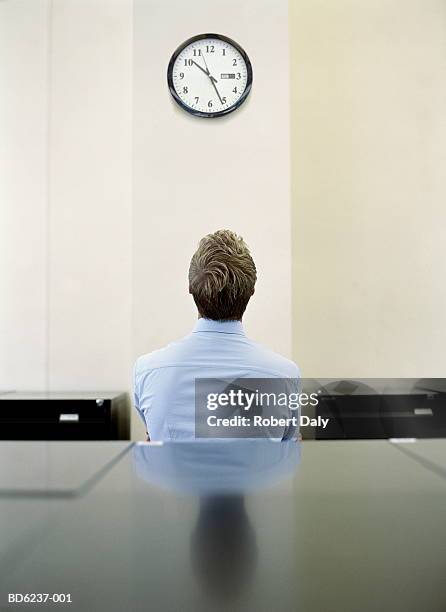 businessman looking at clock - bored worker fotografías e imágenes de stock