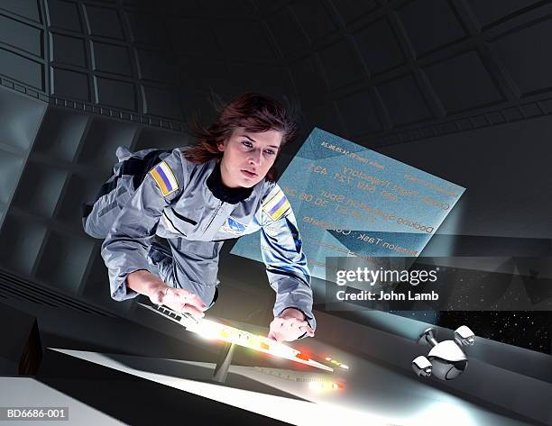 female astronaut floating in space station (digital composite) - raumfahrzeug stock-fotos und bilder