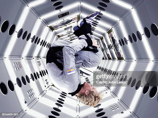 male astronaut floating upside down in space station (composite) - ruimtevaart voertuig stockfoto's en -beelden