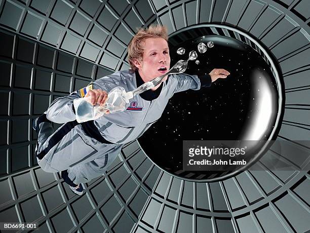 male astronaut floating in space station (digital composite) - space station stock pictures, royalty-free photos & images