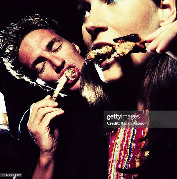 couple eating chicken legs, close-up - messy boyfriend stock pictures, royalty-free photos & images