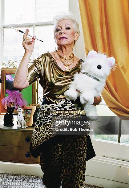 elderly woman with cigarette holder and toy dog, portrait - alleen seniore vrouwen stockfoto's en -beelden