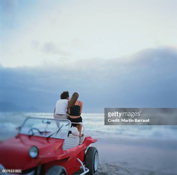 couple sitting on back of beach buggy, rear view - dune buggy stock pictures, royalty-free photos & images