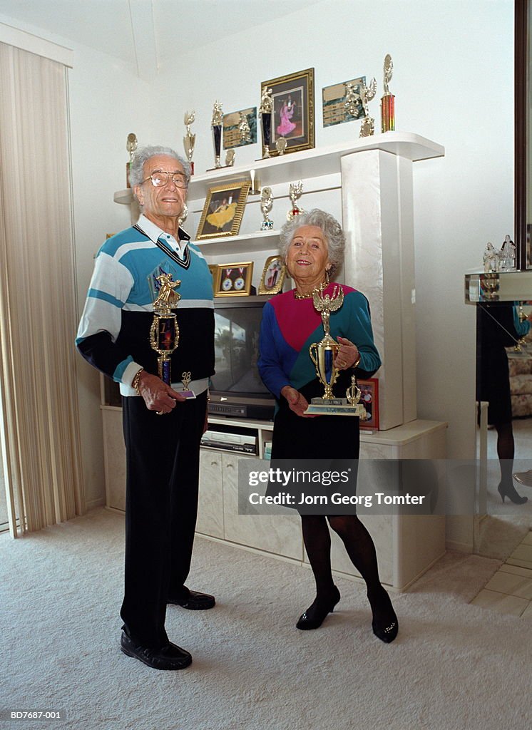 Mature couple holding trophies, portrait