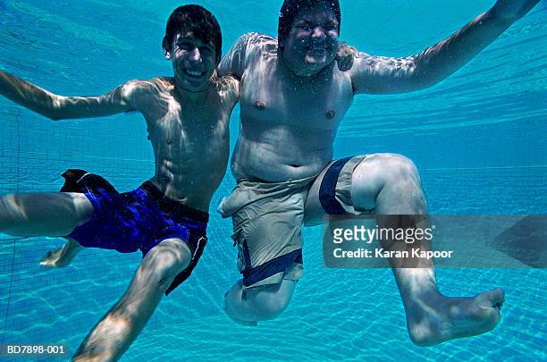 two teenage boys (14-16) in swimming pool, underwater view - skinny teen ストックフォトと画像