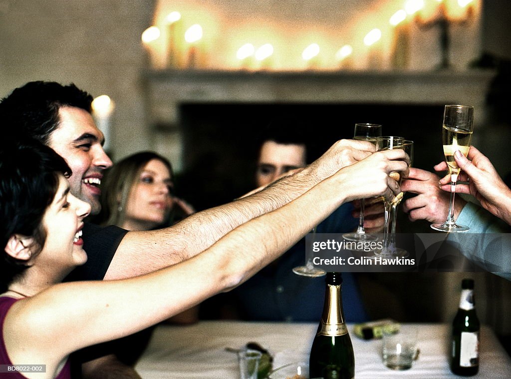 Group of people at table toasting with champagne