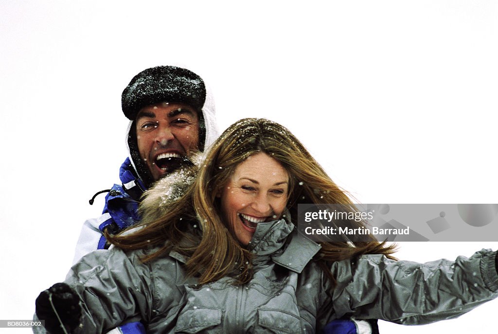 Couple on sledge laughing, portrait, close-up