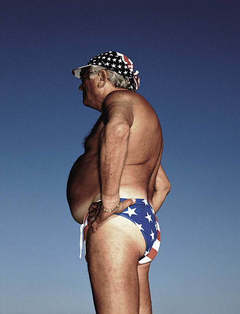 mature man wearing 'stars and stripes' swimming trunks, profile - guy in speedo stock pictures, royalty-free photos & images