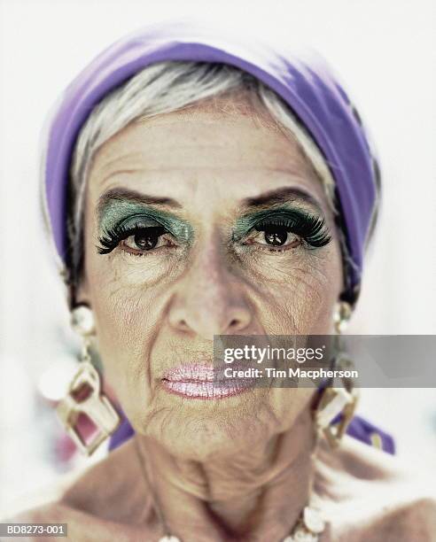 elderly woman wearing make-up and gold earrings, close-up, portrait - ugly woman stock-fotos und bilder