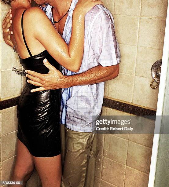 fully clothed couple embracing in shower, close-up - couple and kiss and bathroom 個照片及圖片檔