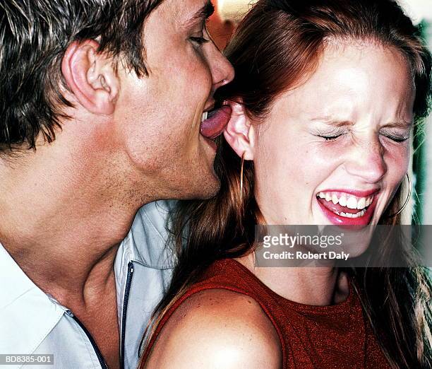 man licking woman's ear, close-up - ear close up women stock-fotos und bilder