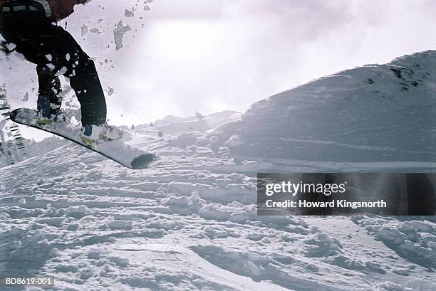 snowboarder making jump, close-up - snowboard jump close up stock pictures, royalty-free photos & images