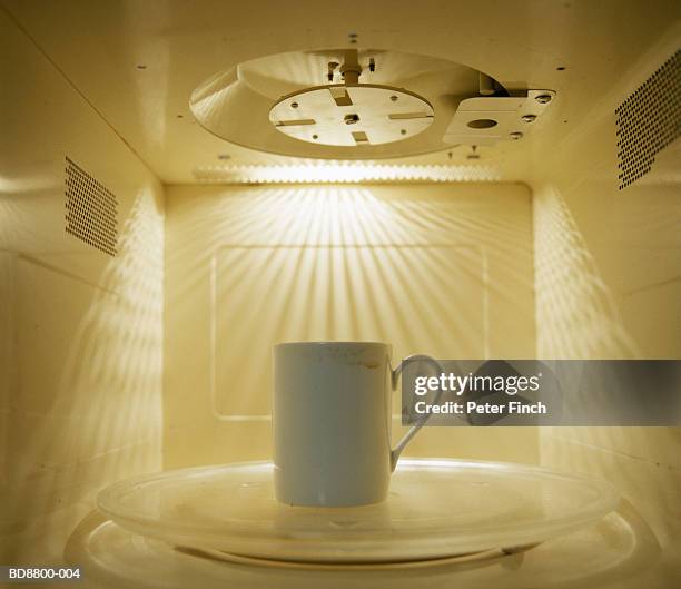 mug inside microwave, close-up - microwave photos et images de collection