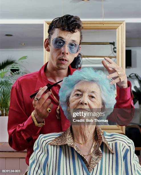 Mature woman having hair styled by male hairdresser