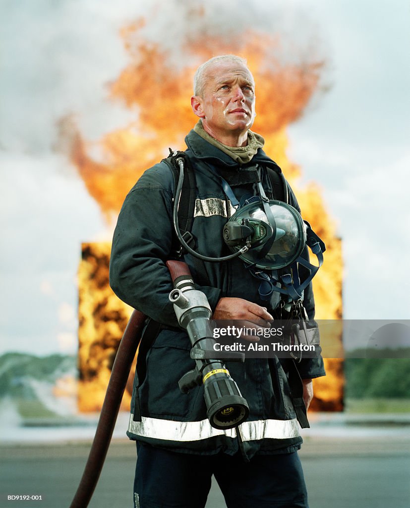 Fireman with hose in front of firewall