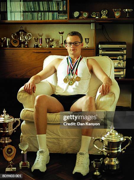 young man wearing medals, surrounded by trophies, portrait - awards winners room stock pictures, royalty-free photos & images