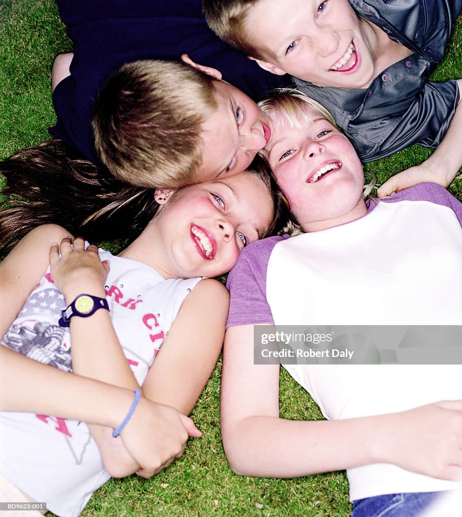 Group of children (11-13) lying on grass, smiling, elevated view