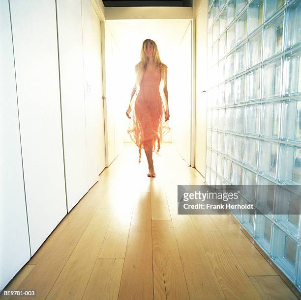 young woman walking down corridor (digital enhancement) - glass cube fotografías e imágenes de stock