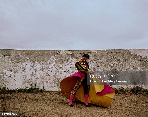 matador swinging cloak in arena, portrait - bullfighter stock-fotos und bilder