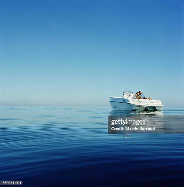 couple relaxing on speedboat - motorboot stockfoto's en -beelden