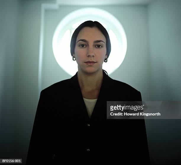 woman standing in front of door with circular window, portrait - halo stock pictures, royalty-free photos & images