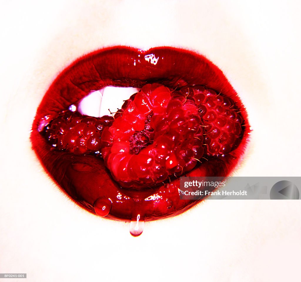 Woman eating raspberries, close-up (digital enhancement)