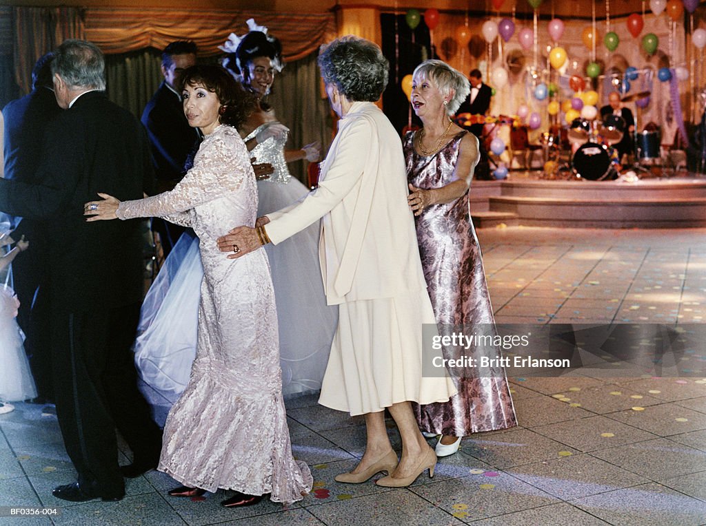 Bride and groom leading conga on dance floor