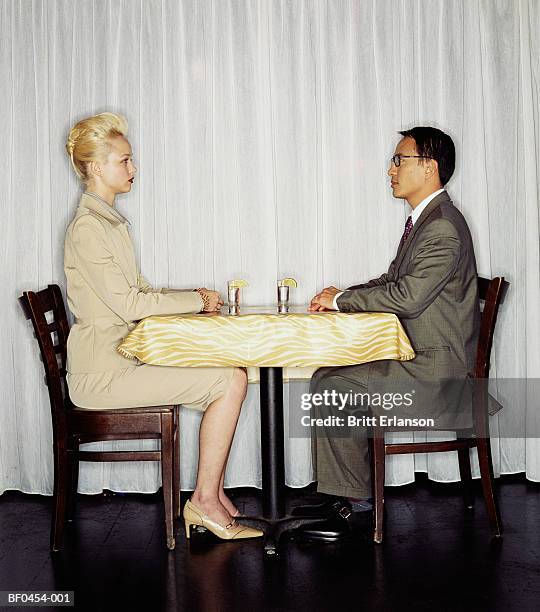 young couple sitting at table, face to face - jantar romantico imagens e fotografias de stock