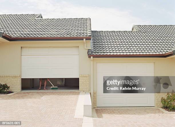 man sweeping inside garage, low section - garage doors stock pictures, royalty-free photos & images