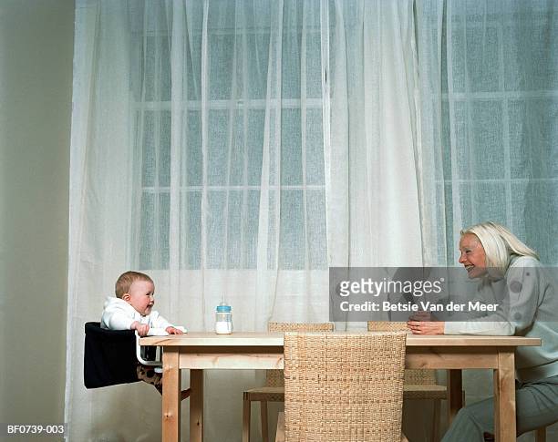 grandmother talking to baby (6-9 months) across table, profile - white van profile stock pictures, royalty-free photos & images