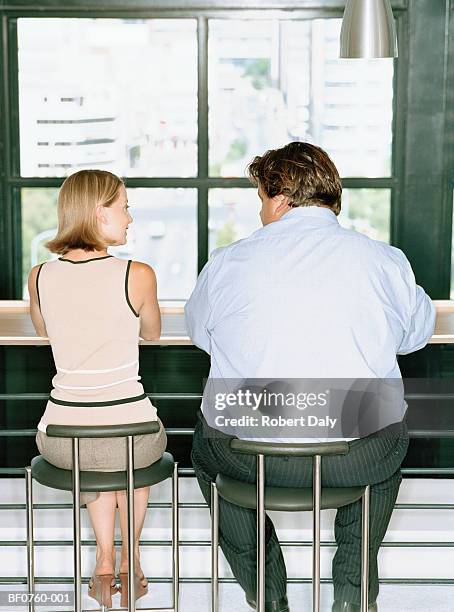 petit woman and overweight businessman at table, rear view - schlank stock-fotos und bilder