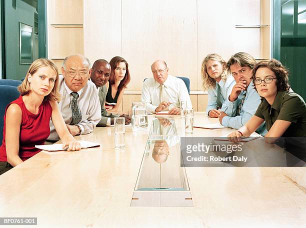 office workers at boardroom table, portrait - aergerlich stock-fotos und bilder