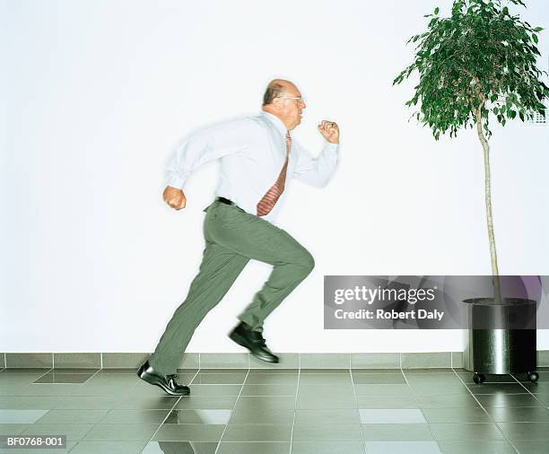 businessman running along corridor, profile - run shirt stock-fotos und bilder