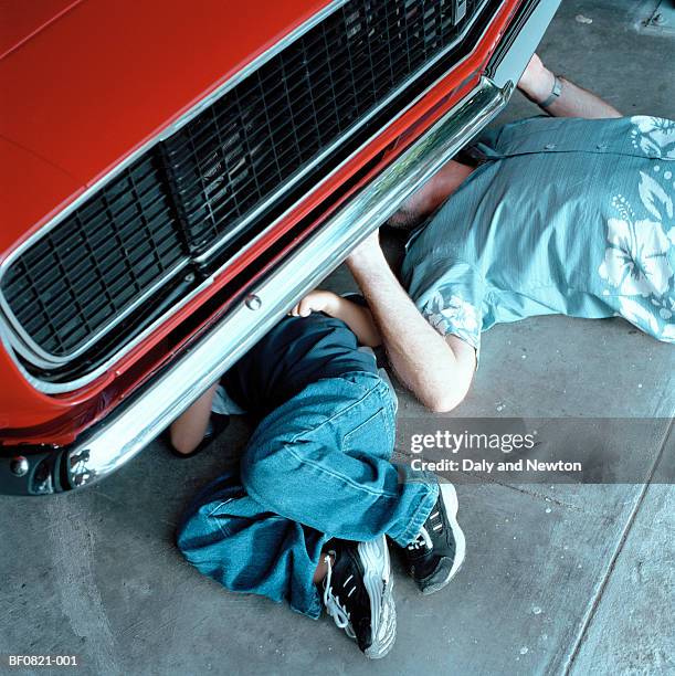 boy (4-6) and man fixing car, elevated view - parte inferior fotografías e imágenes de stock