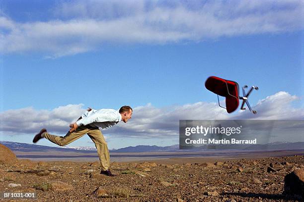 young man throwing office chair through air (blurred motion) - kaldidalur stock pictures, royalty-free photos & images