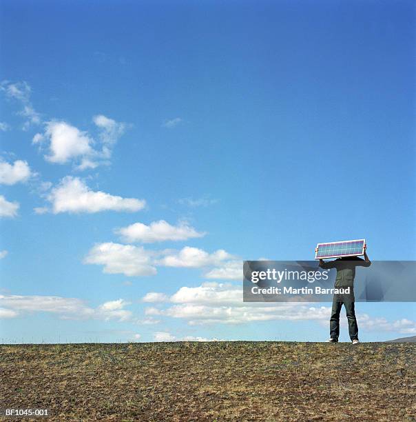 iceland, kaldidalur, man holding up solar panel over face - kaldidalur fotografías e imágenes de stock