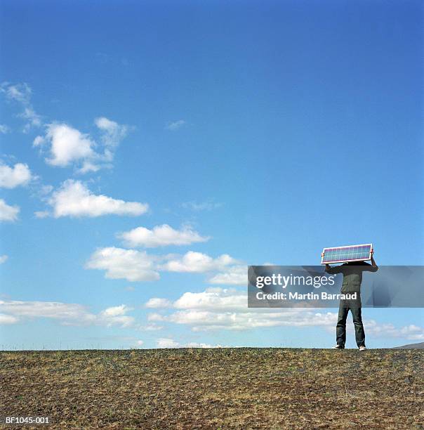 iceland, kaldidalur, man holding up solar panel over face - kaldidalur stock pictures, royalty-free photos & images