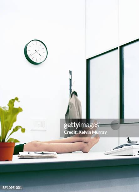female executive in office, resting  bare feet on desk, low section - womans bare feet fotografías e imágenes de stock
