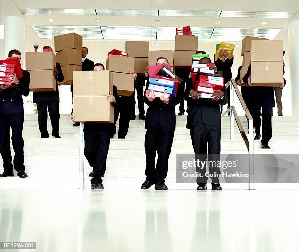 group of businessmen carrying boxes and ring binders down stairs - bureaucracy stock pictures, royalty-free photos & images