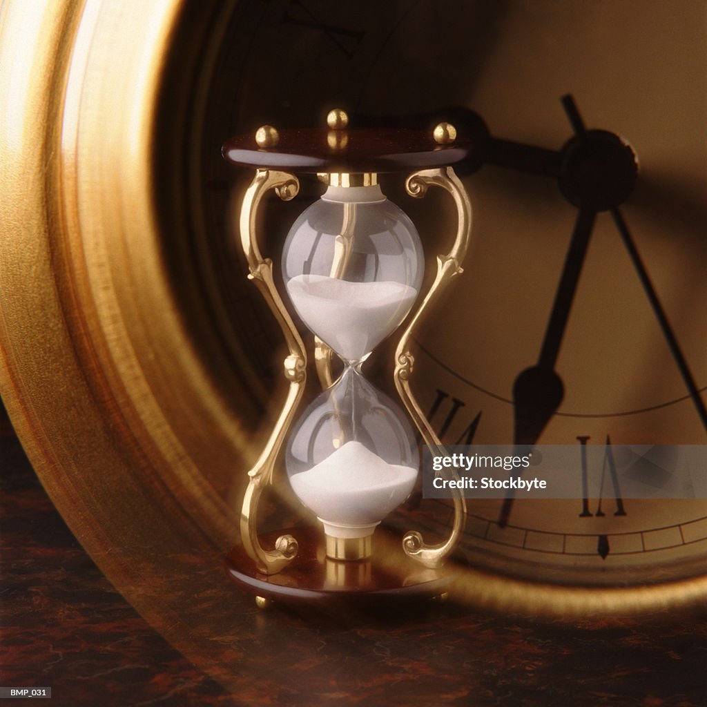 Hourglass in front of clock