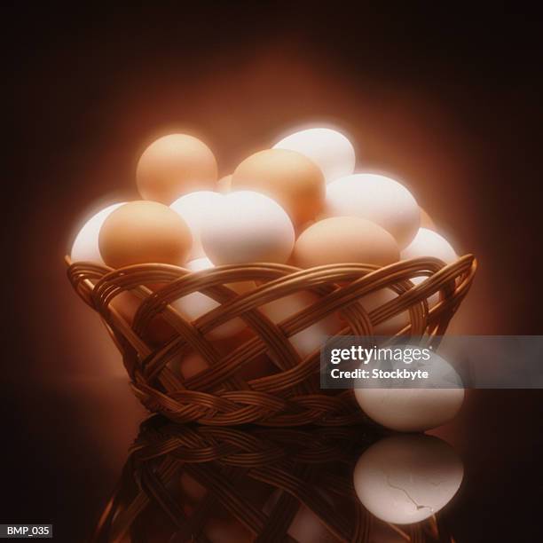 basket of eggs; lone egg on table beside basket - overconfidence stock pictures, royalty-free photos & images