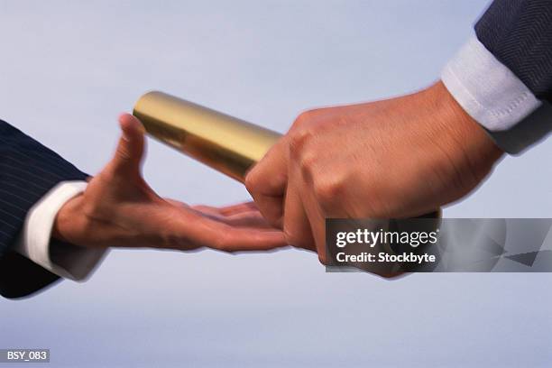 two hands exchanging baton - relay baton stock pictures, royalty-free photos & images