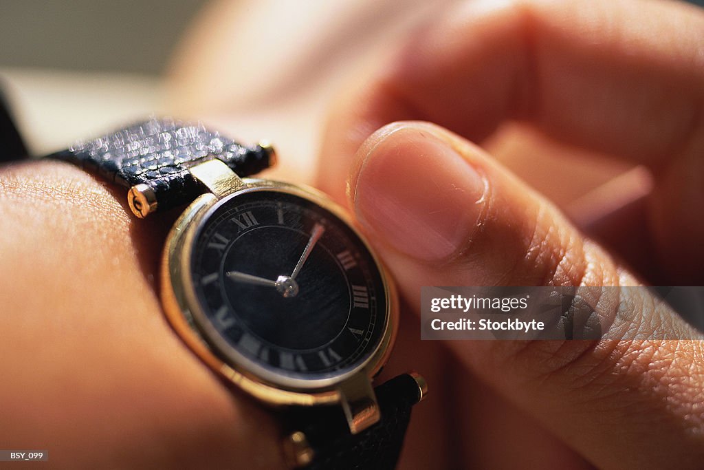 Woman adjusting watch  close-up