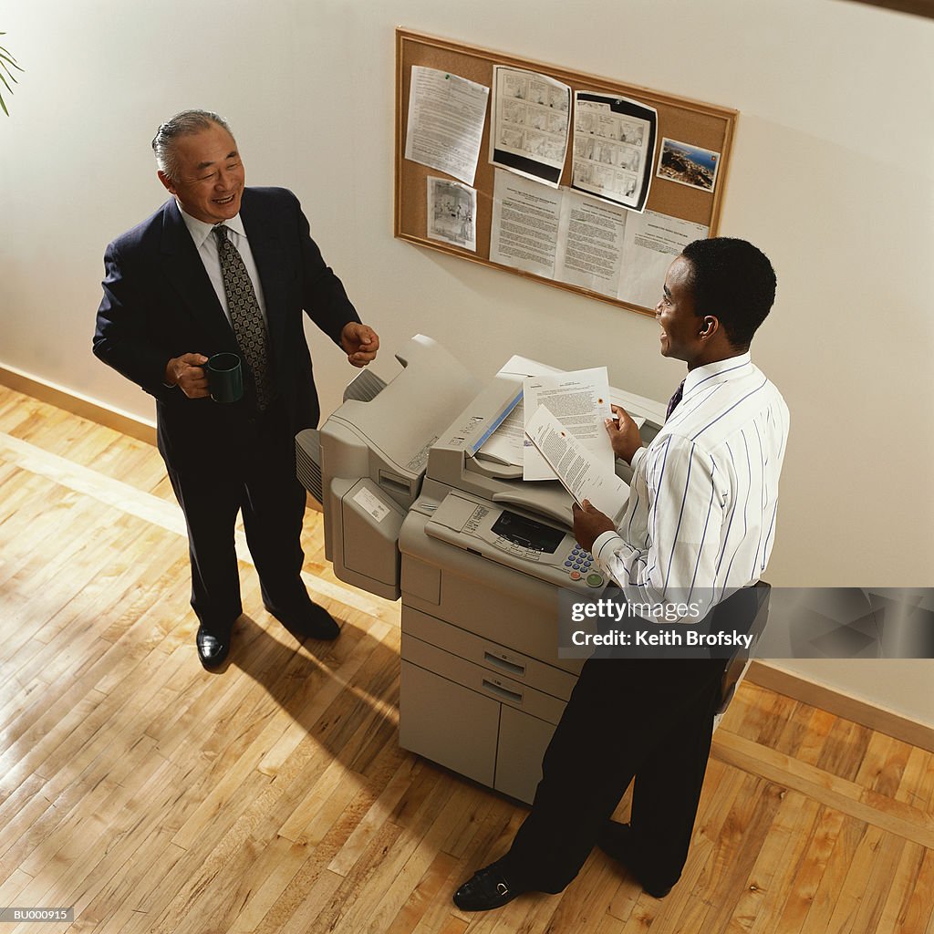 Businessmen Talking at Photocopier