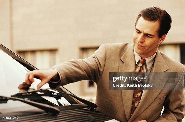 businessman reaching for citation on car - infrações de estacionamento - fotografias e filmes do acervo