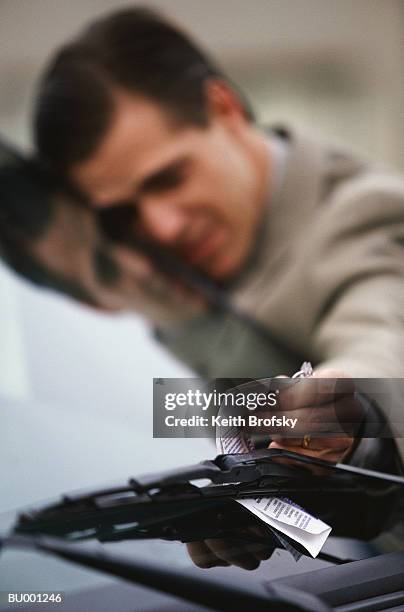 businessman reaching for citation on car - infrações de estacionamento - fotografias e filmes do acervo